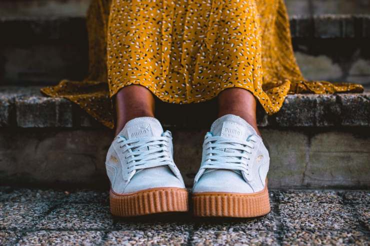 ragazza seduta con scarpe da ginnastica e gonna