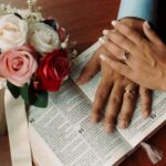 bibbia, fiori e mani con fedi