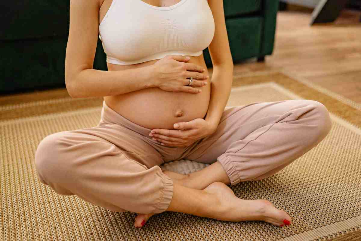 donna incinta seduta a terra