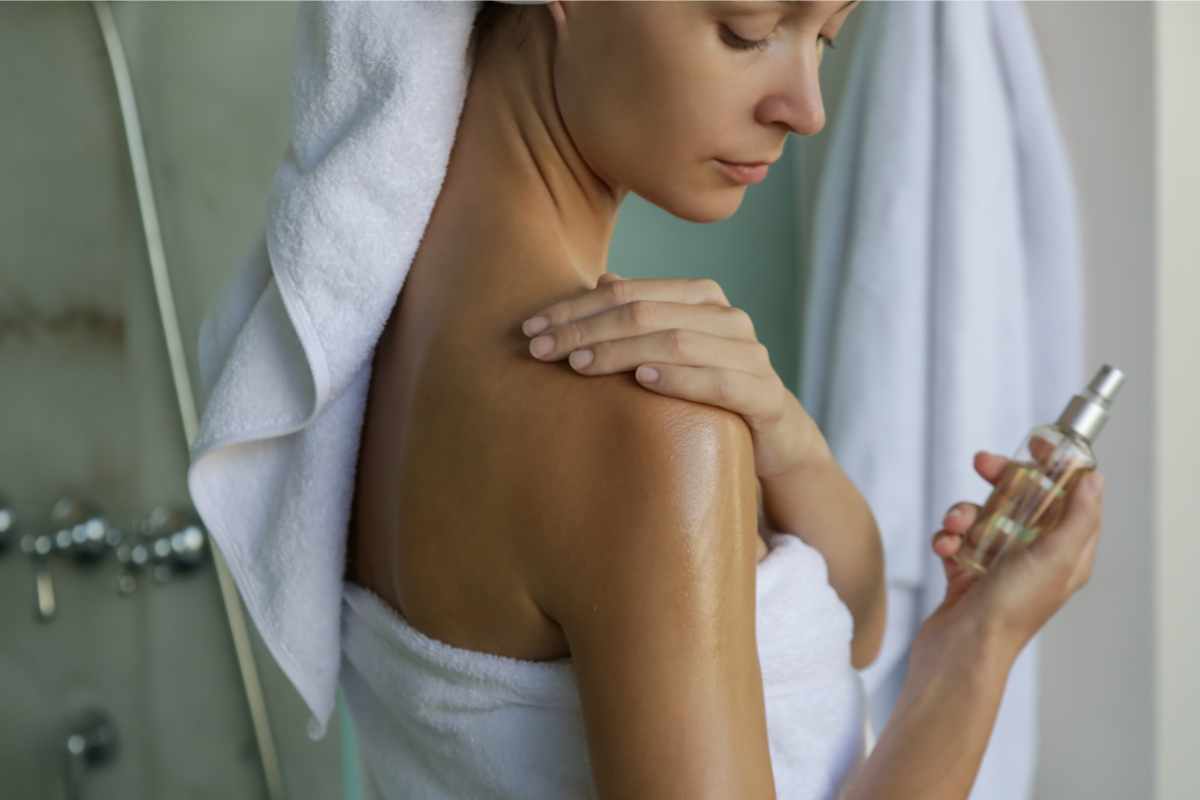 donna che applica olio secco sul corpo