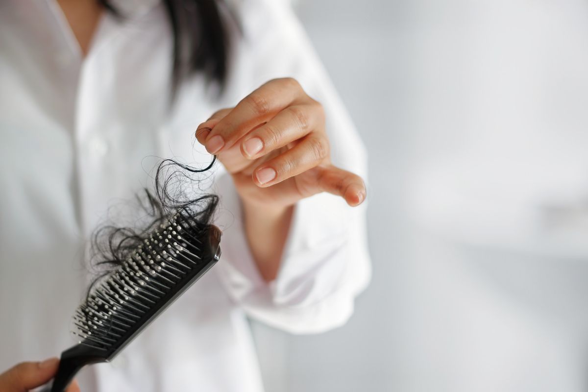 persona che toglie capelli dalla spazzola