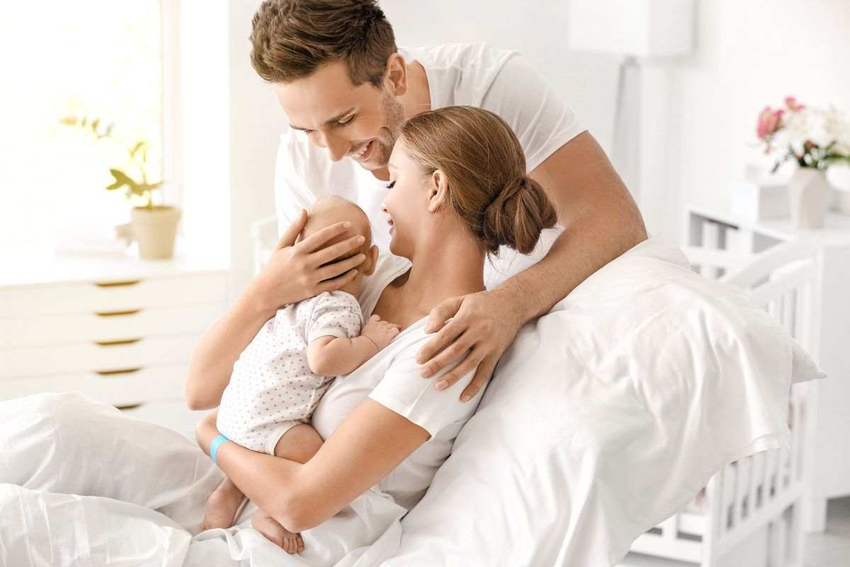 coppia felice con neonato in braccio