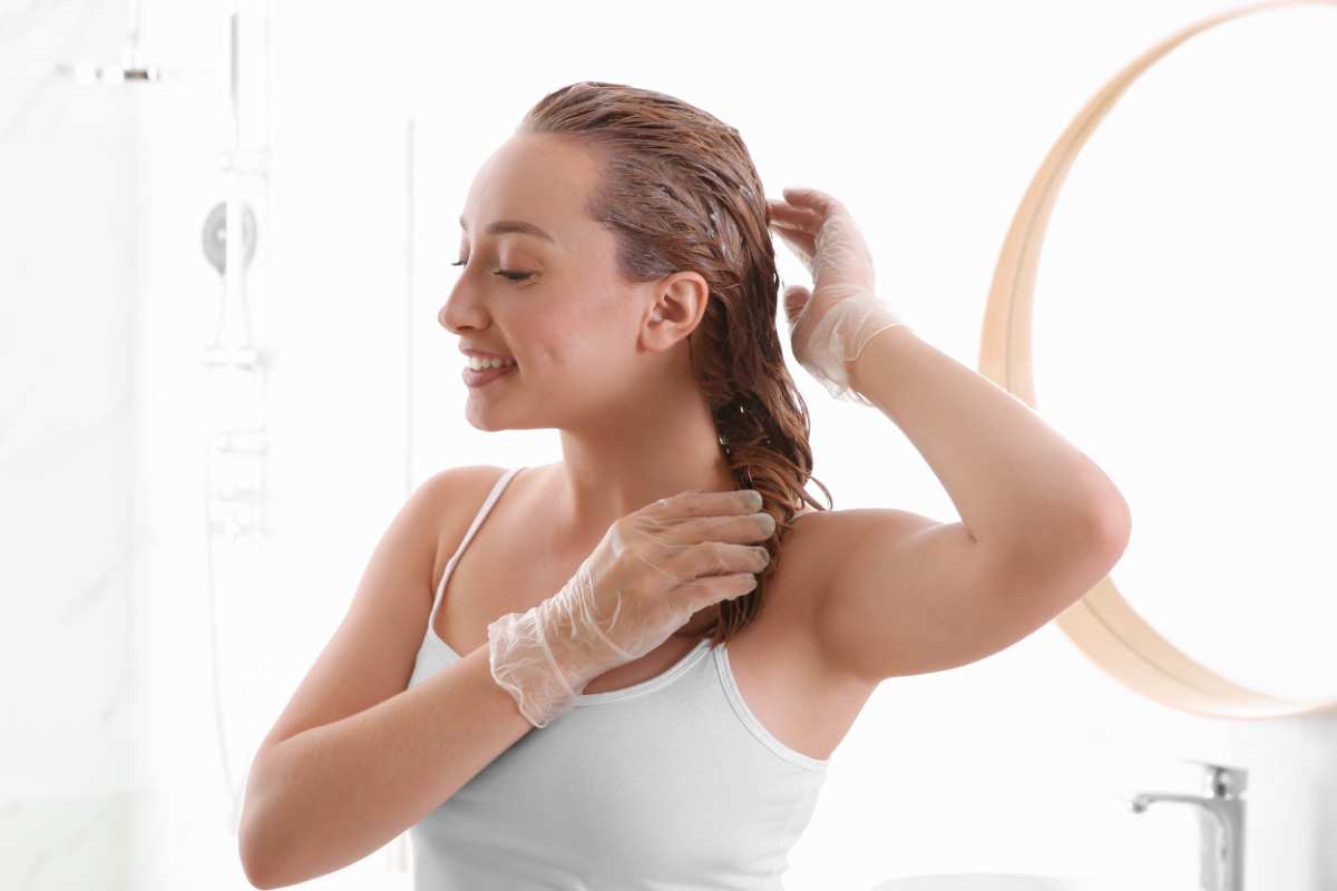 donna che si tinge i capelli in bagno