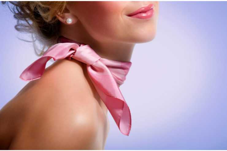 donna con foulard rosa al collo e orecchini