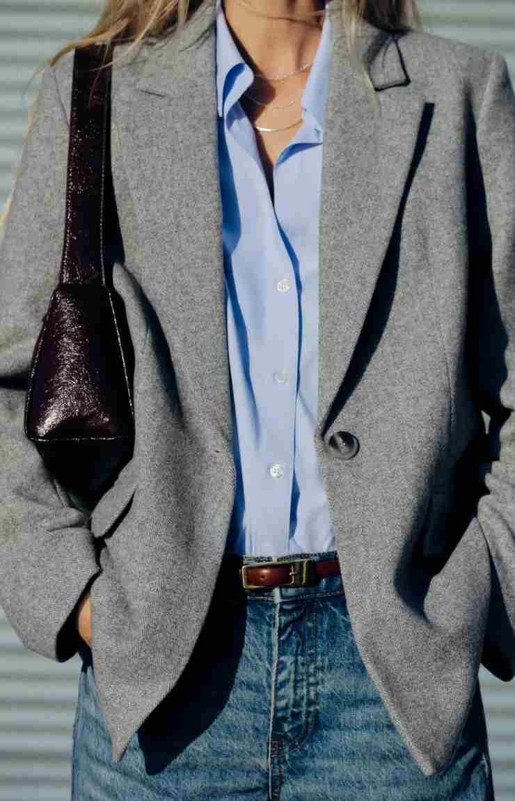 modella blazer grigio camicia celeste jeans e borsa a spalla