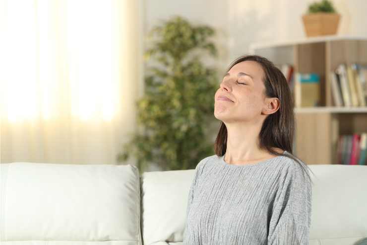 donna con occhi chiusi che fa esercizio di respirazione