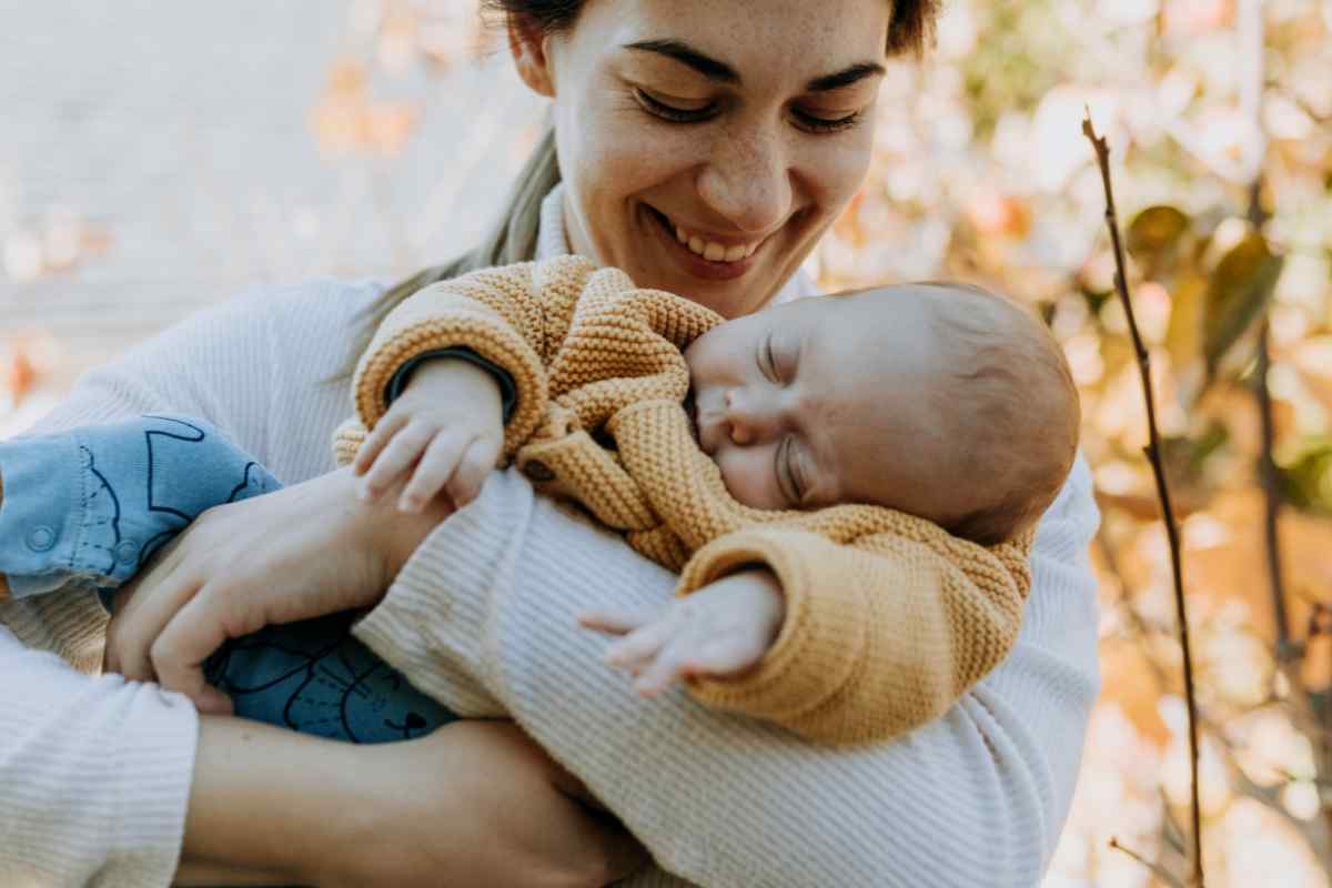 mamma sorridente con neonato in braccio