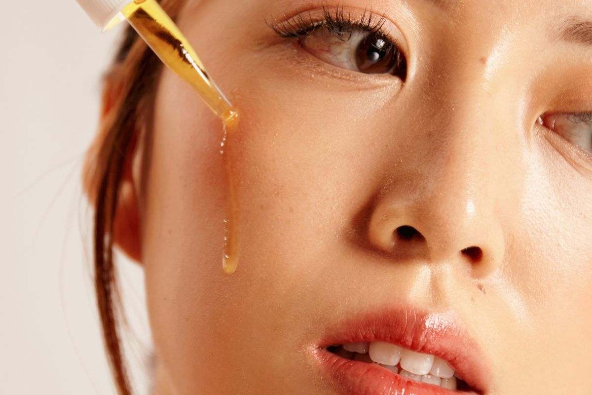 ragazza che applica siero sul viso