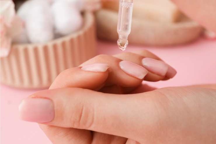 donna che applica olio per le cuticole