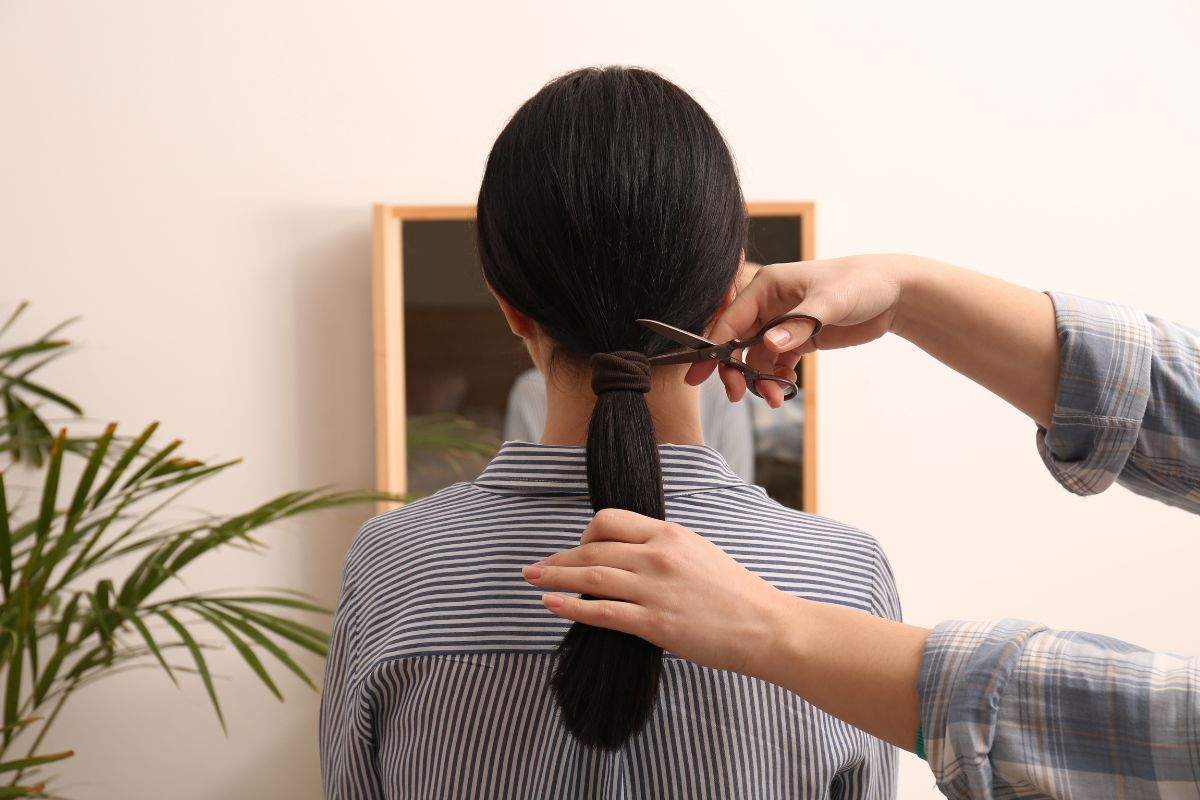 ragazza di spalle che si fa tagliare i capelli