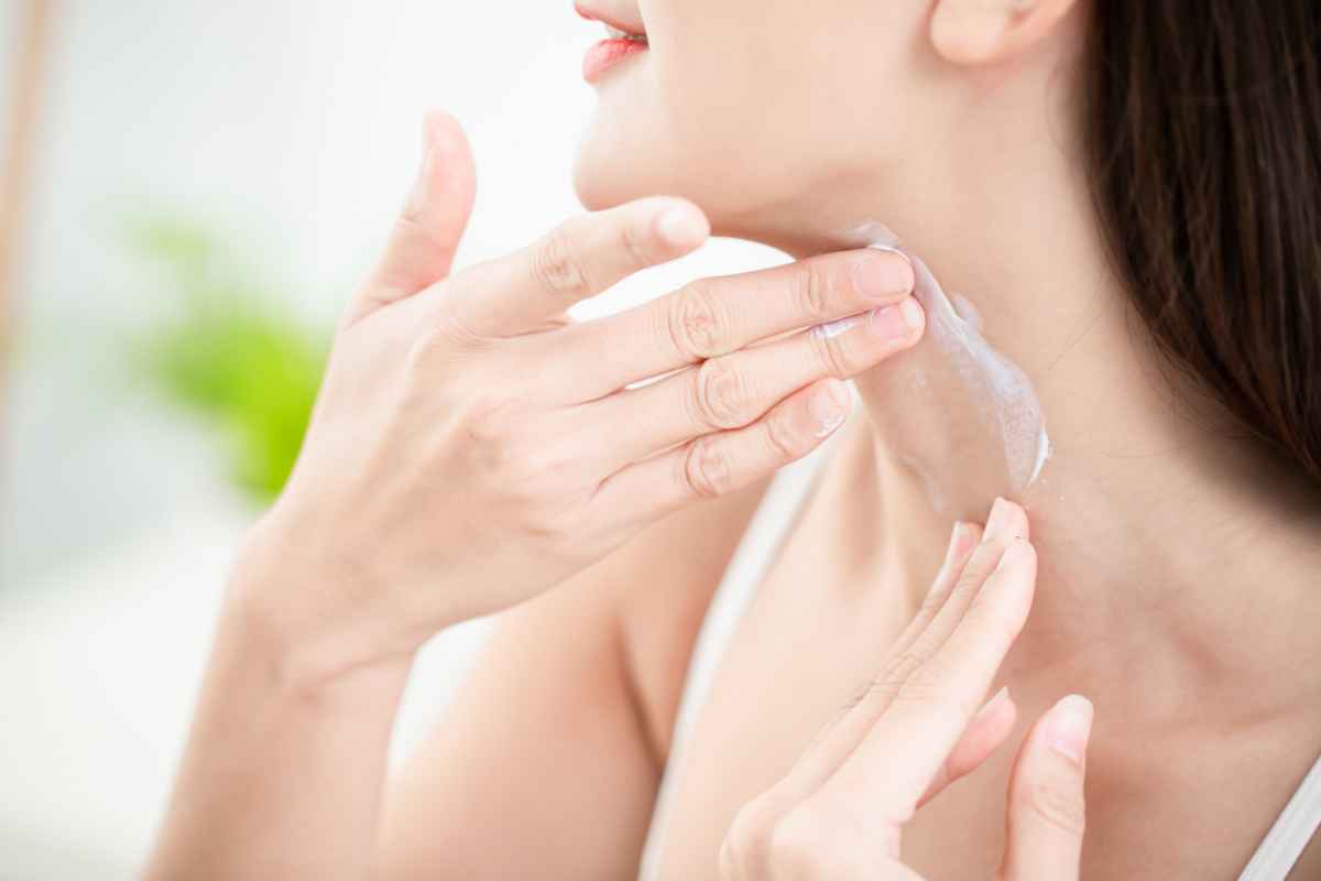 donna che applica crema sul collo