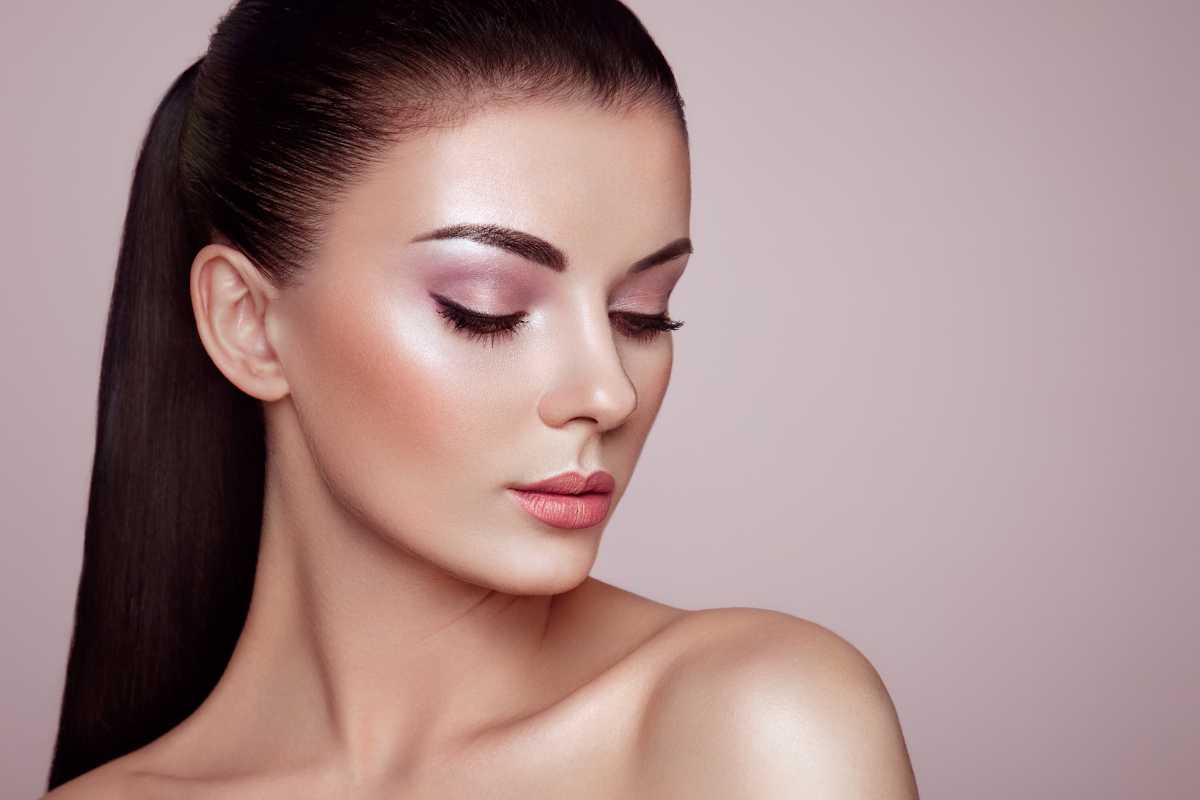 donna truccata con illuminante viso su naso, fronte e zigomi