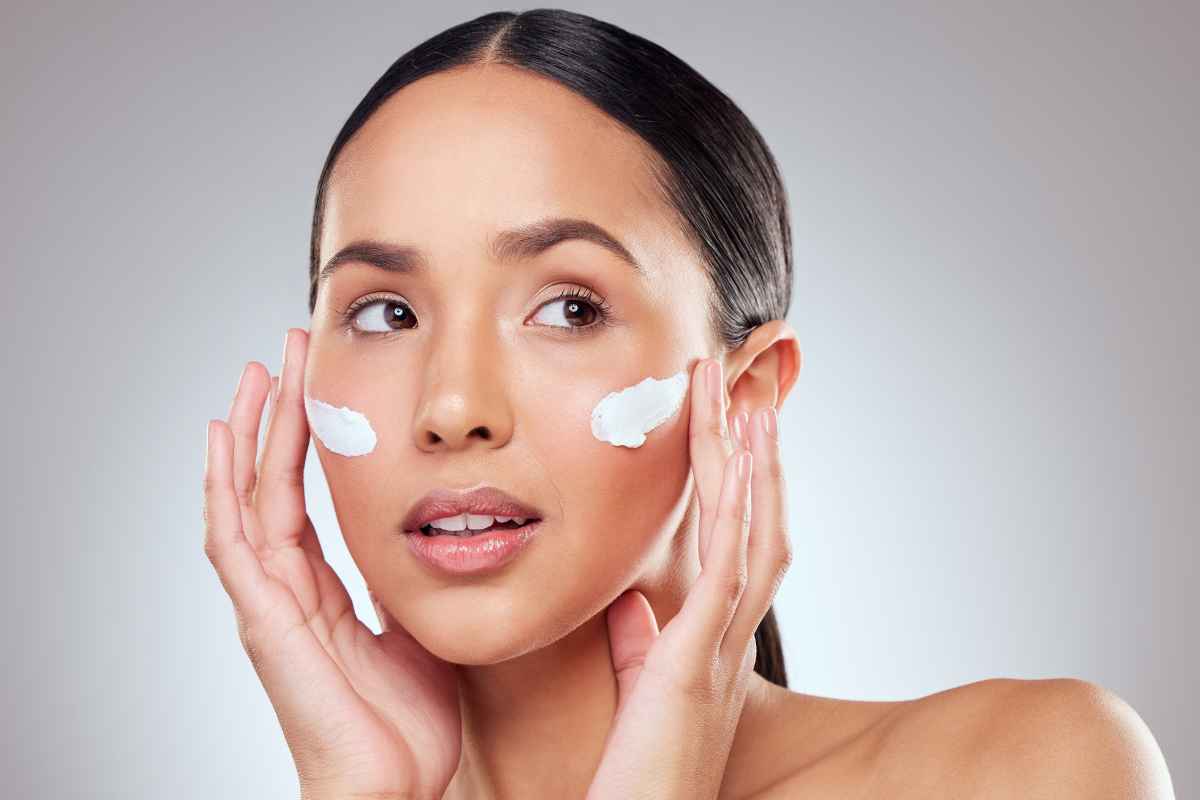 donna con pelle sensibile che applica crema viso