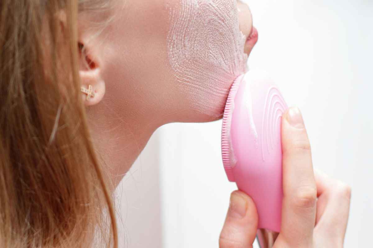 dettaglio donna che usa massaggiatore elettrico viso
