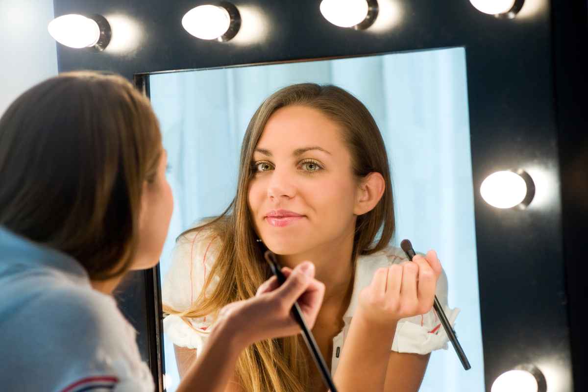 ragazza che si trucca allo specchio con luce LED