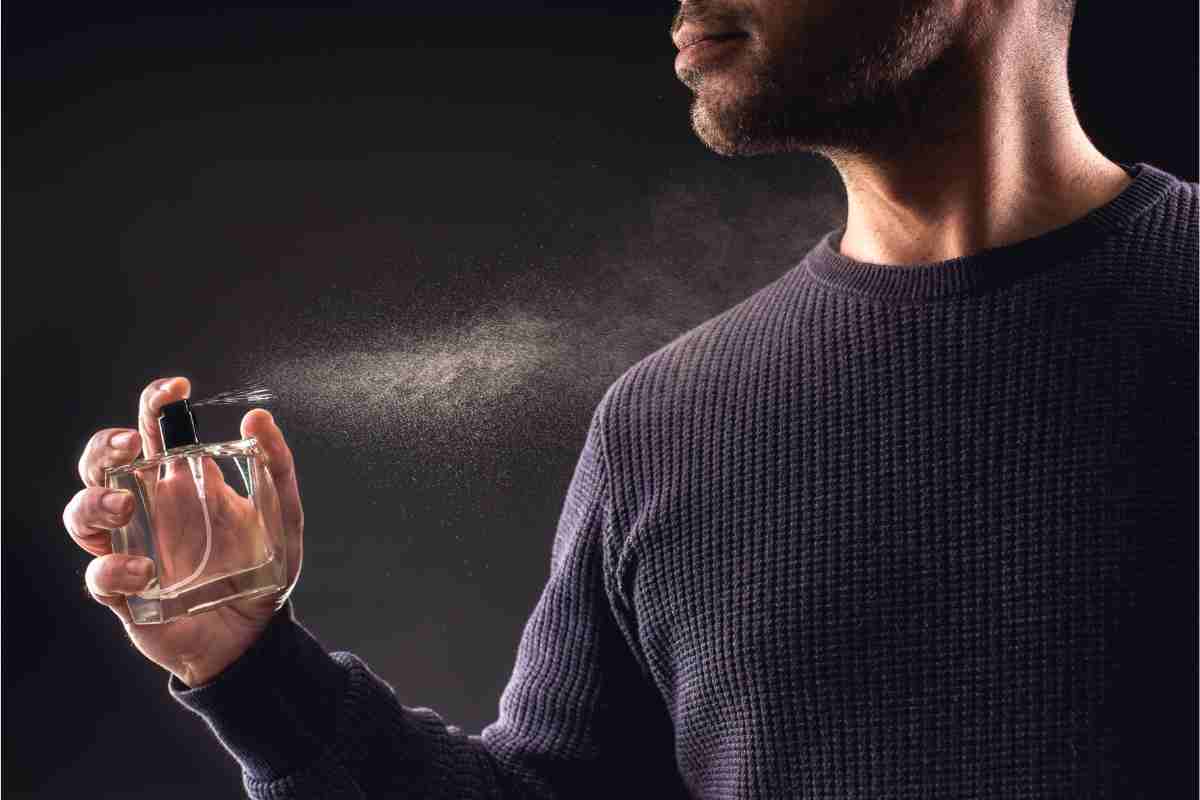 uomo che spruzza il profumo