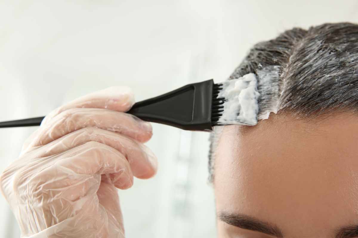 primo piano donna che si tinge i capelli in casa