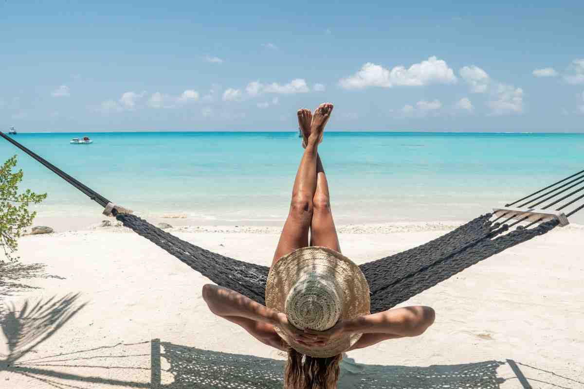 donna sdraiata su un amaca su una spiaggia tropicale