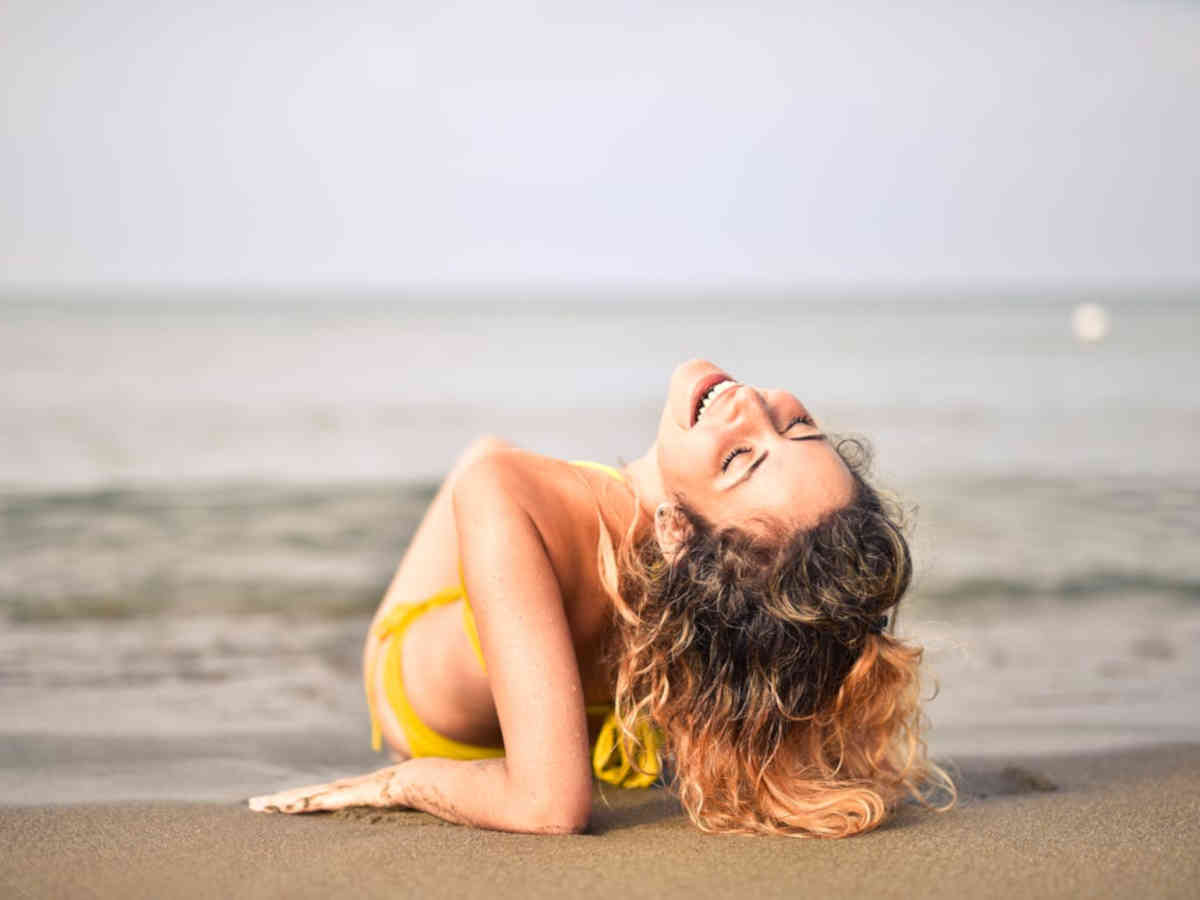 Ragazza che ride in riva al mare