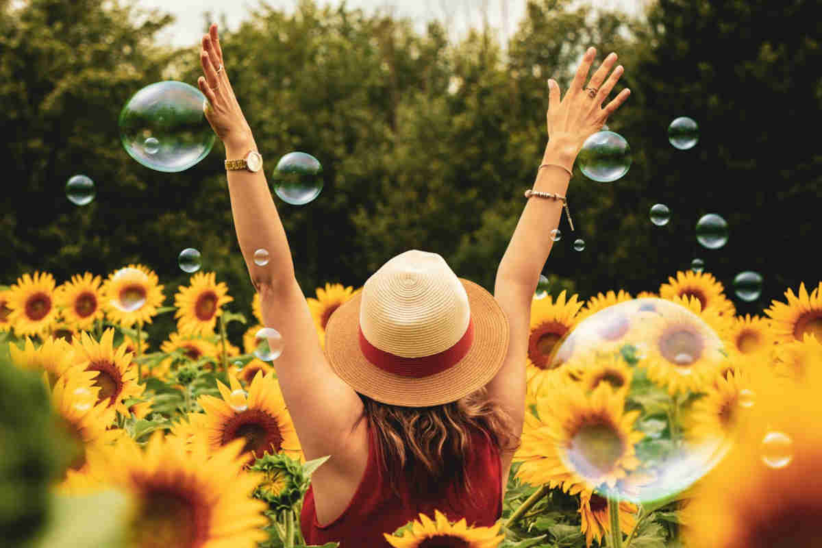 Ragazza felice di spalle in mezzo ai fiori