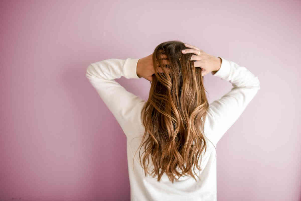 Ragazza di spalle con capelli lunghi e folti