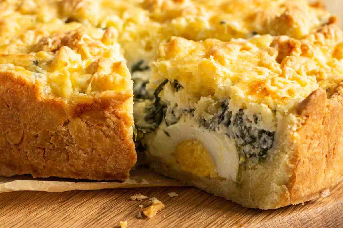 torta pasqualina con fetta tagliata su tagliere