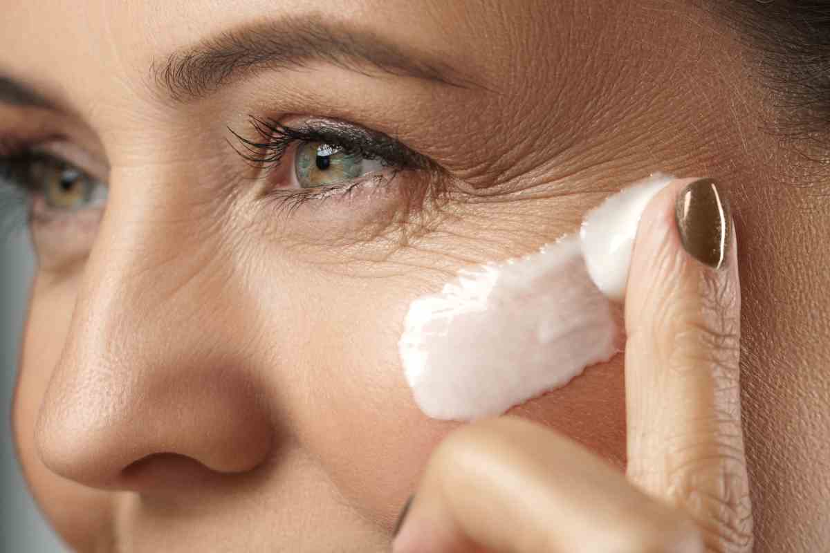 donna stende la crema visto antirughe adatta per l'estate