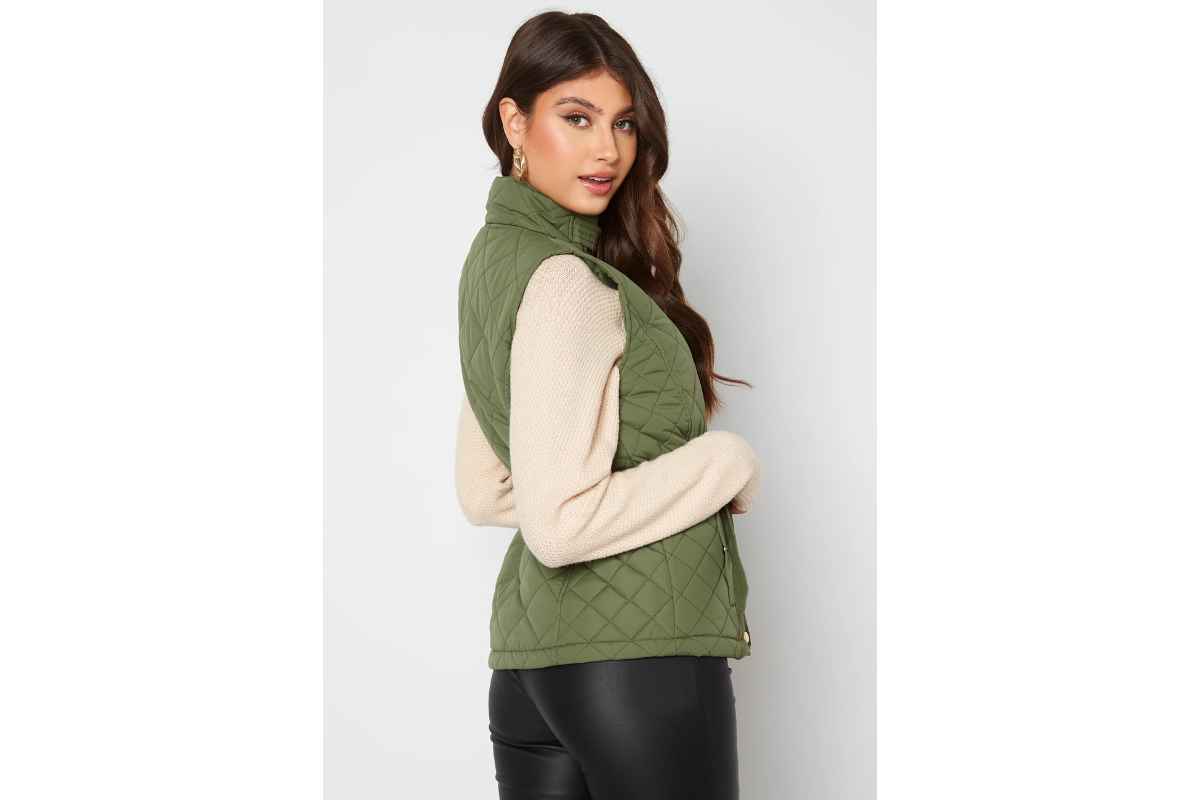 Ragazza indossa un piumino smanicato verde