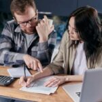 persone hce fanno conti con foglio e calcolatrice