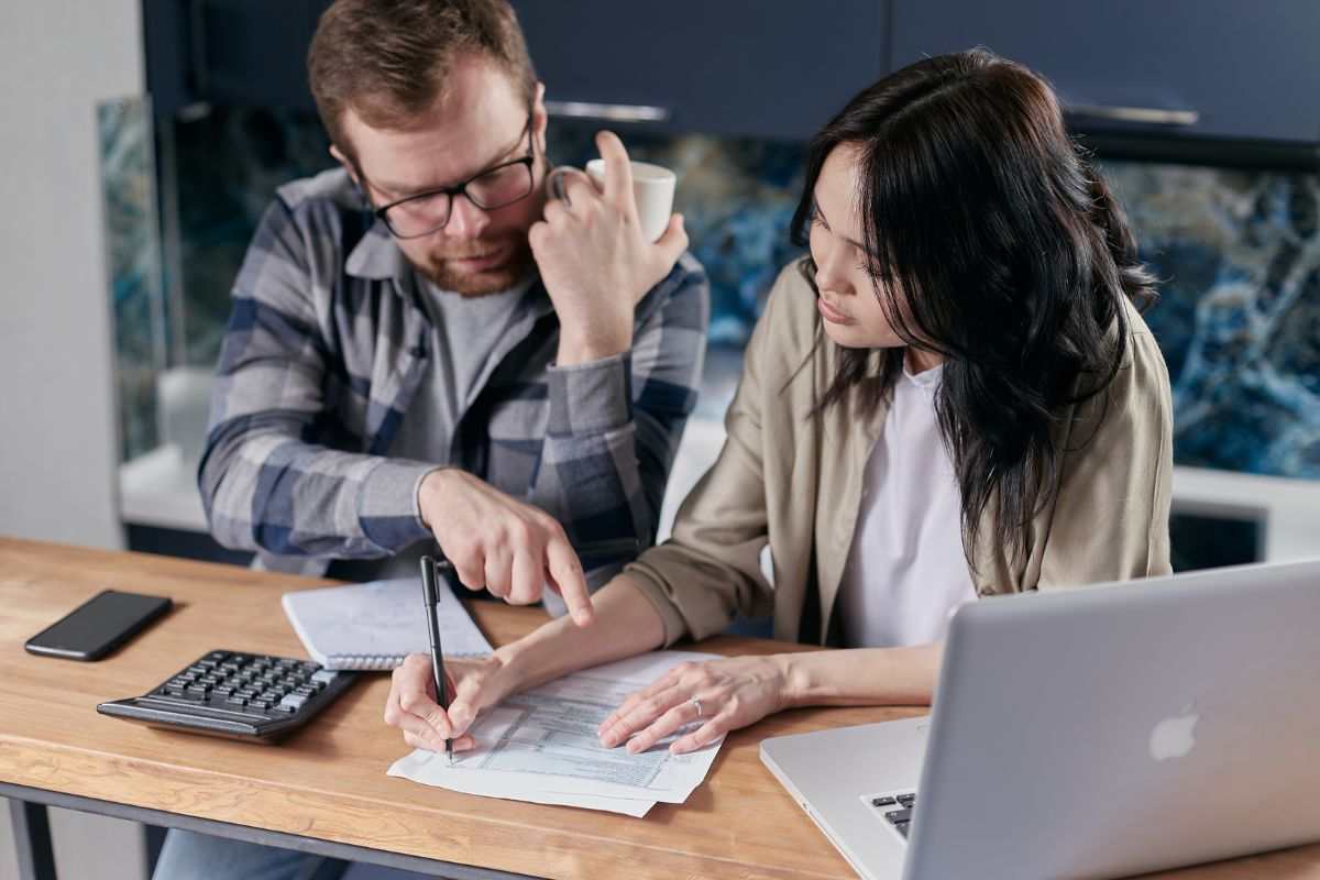 persone hce fanno conti con foglio e calcolatrice