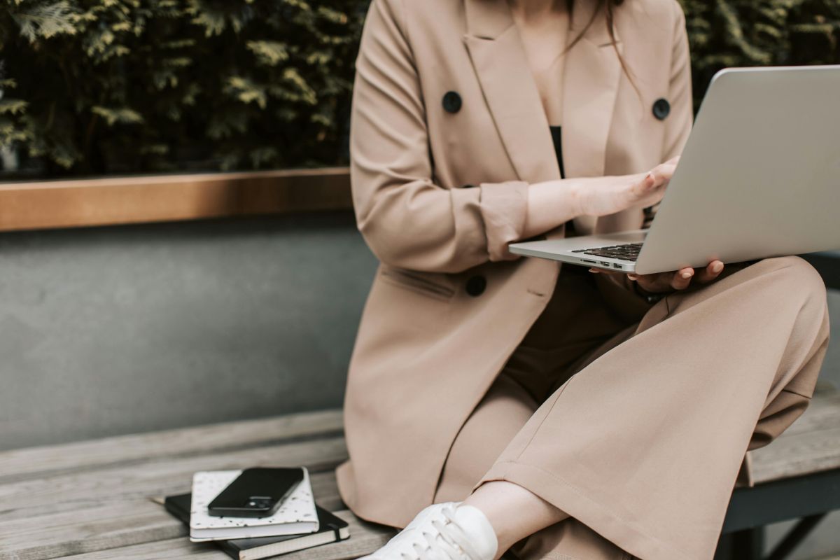 Donna al laptop con cappotto elegante