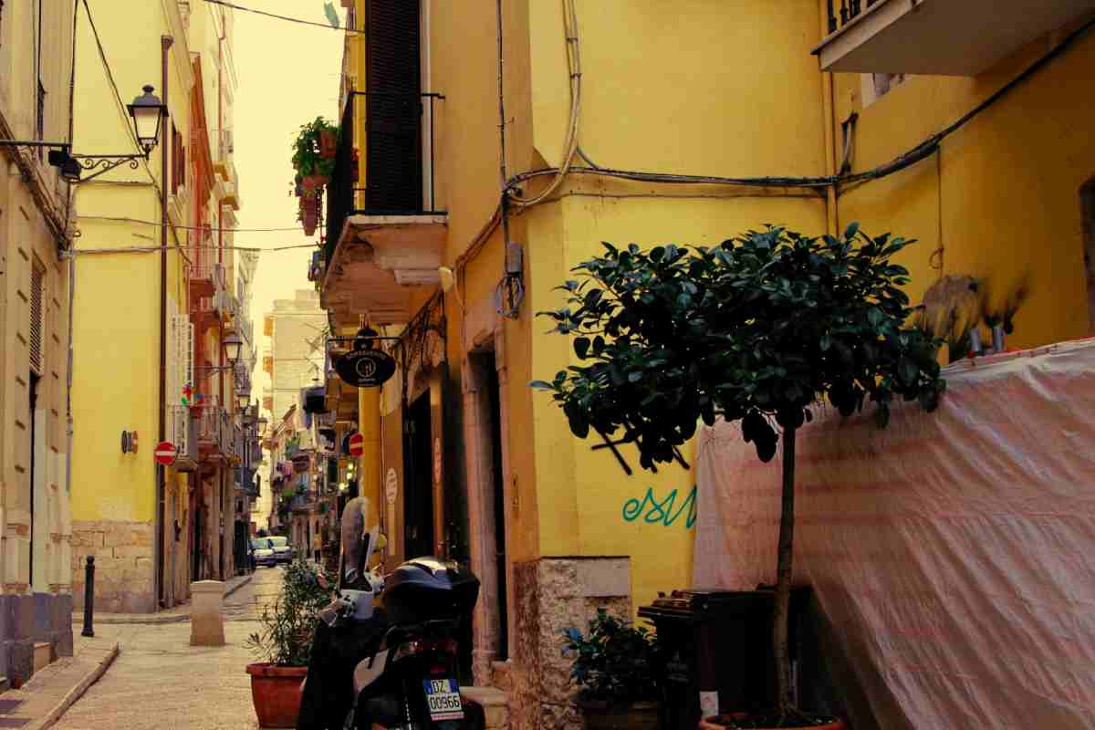 Uno scorcio di un vicolo di un paese italiano, con un motorino parcheggiato