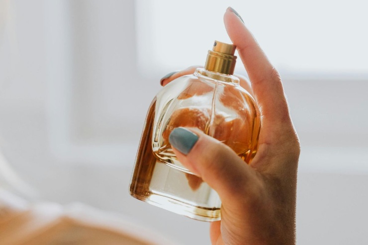 boccetta profumo in mano a una persona