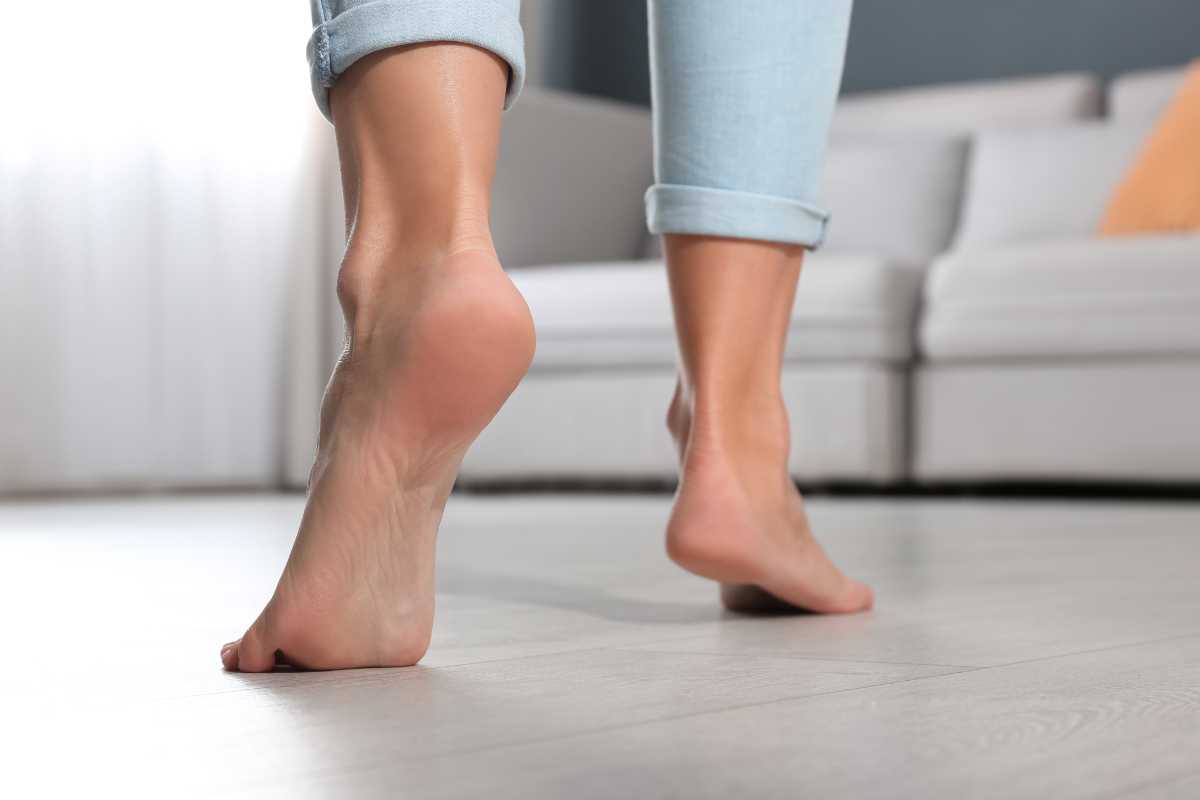 piedi nudi di donna che cammina sul pavimento in casa