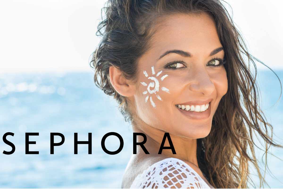 ragazza sorridente con crema solare sul viso e logo sephora