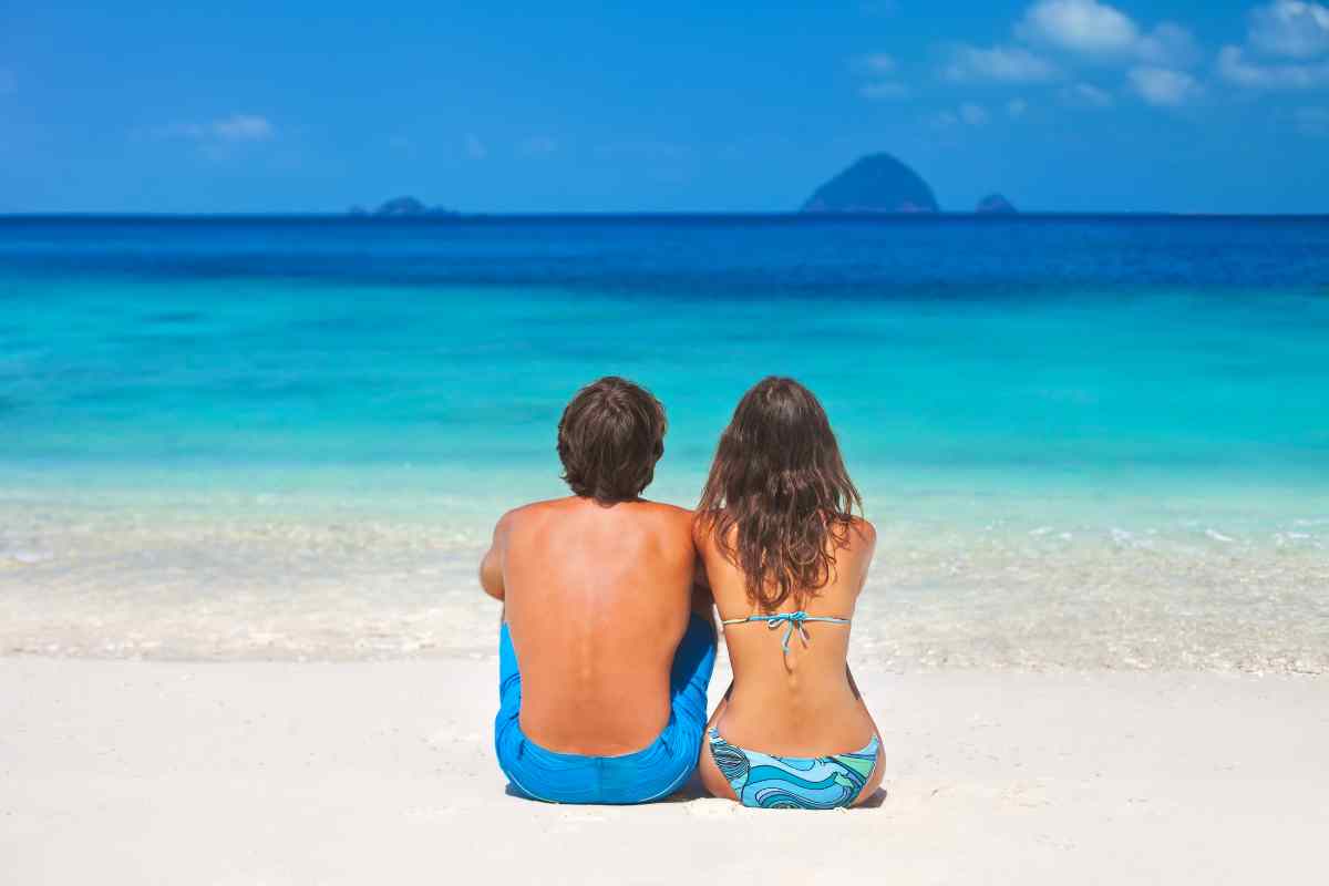 coppia su una spiaggia deserta per le vacanze al mare economiche
