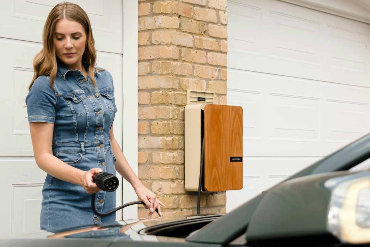 Ragazza che ricarica un'auto elettrica