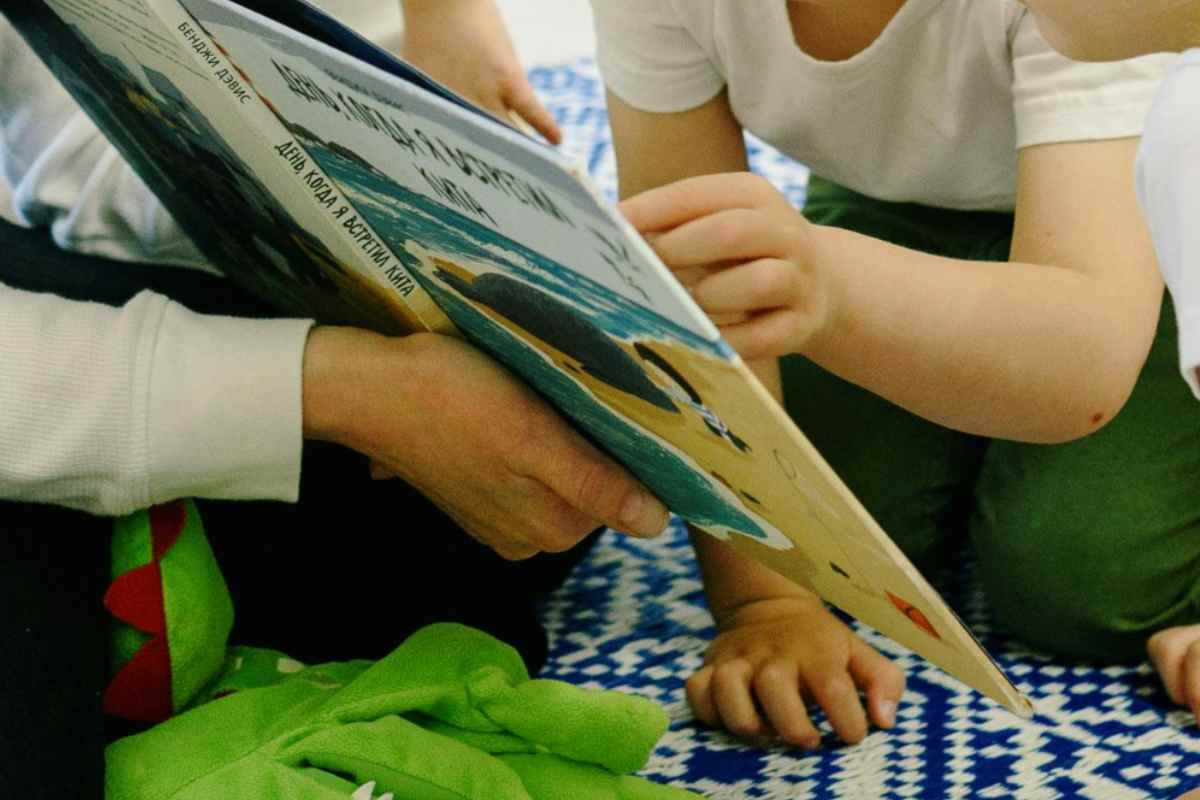 Bambino che tocca un libro in un asilo nido, particolare