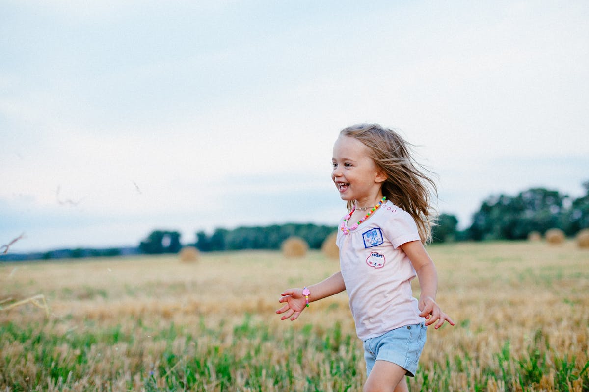 Bimba che corre in un prato