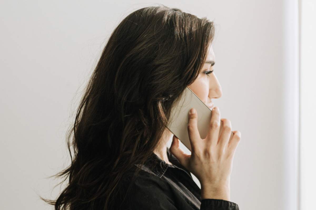 Ragazza di profilo che parla al telefonino