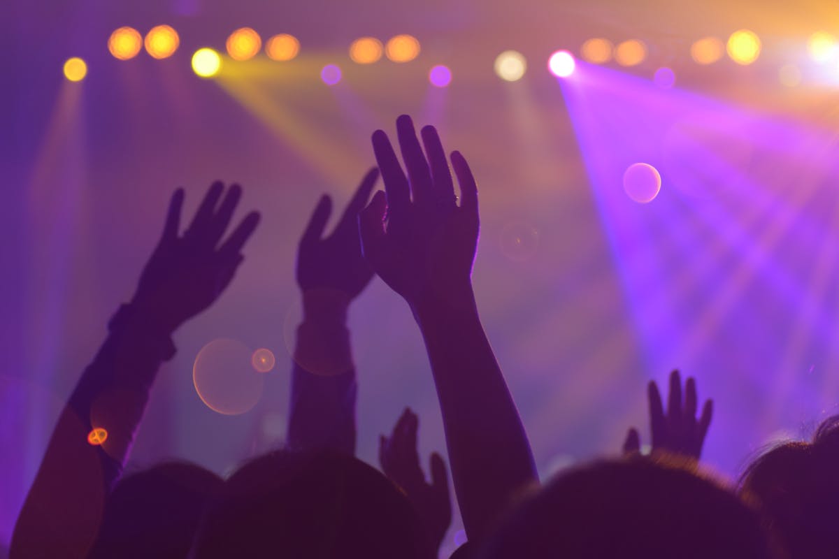 Persone che alzano le mani durante concerto in discoteca