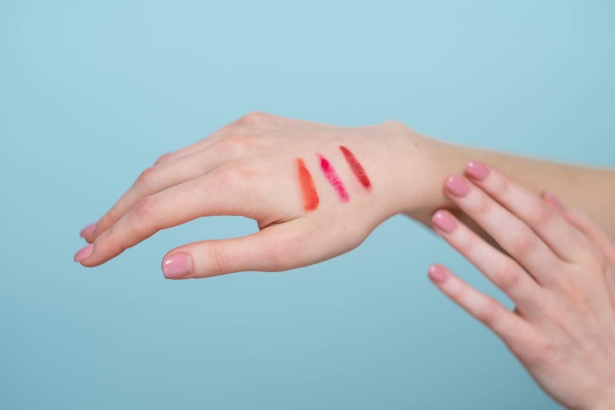 mano con strisce di smalti rosati