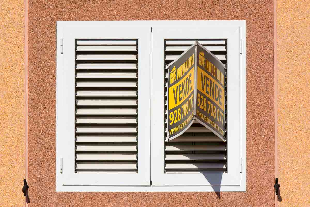 Una finestra di un appartamento con il cartello Vendesi