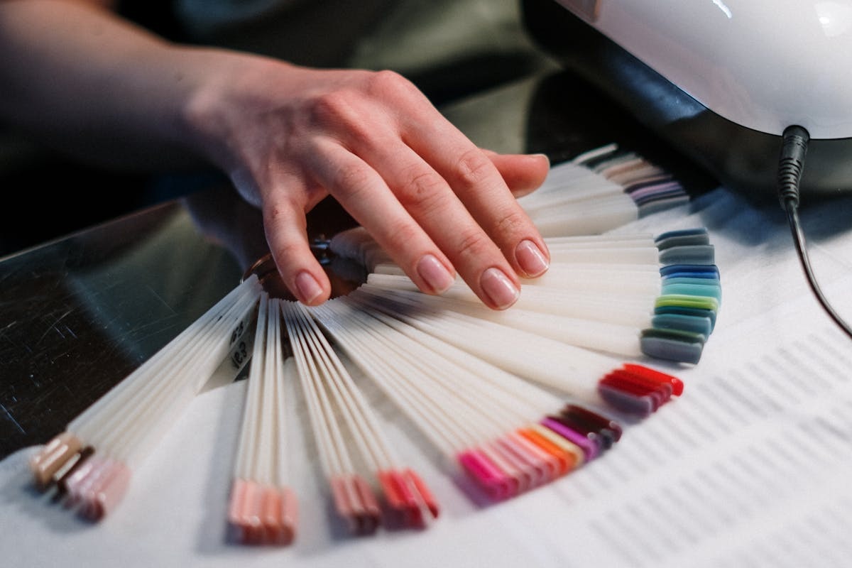 Mano che tiene ferme palette colorazioni smalti