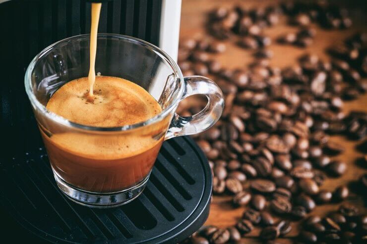 Macchinetta da cui esce caffè nella tazzina 