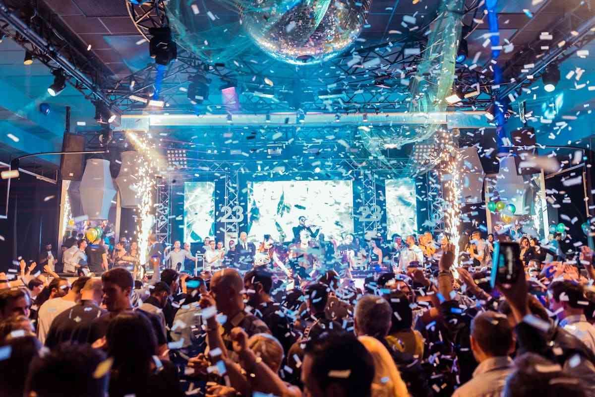 discoteca gremita di persone, coriandoli lanciati