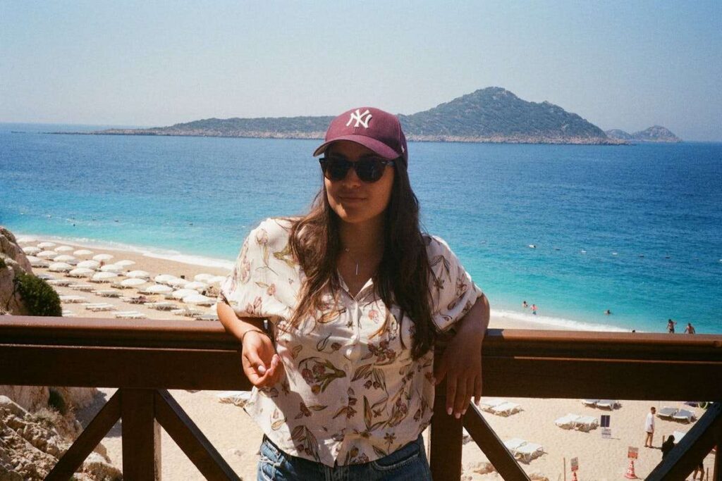 donna poggiata su ringhiera con mare sfondo