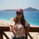 donna poggiata su ringhiera con mare sfondo
