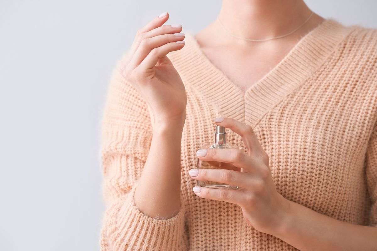 donna che applica profumo