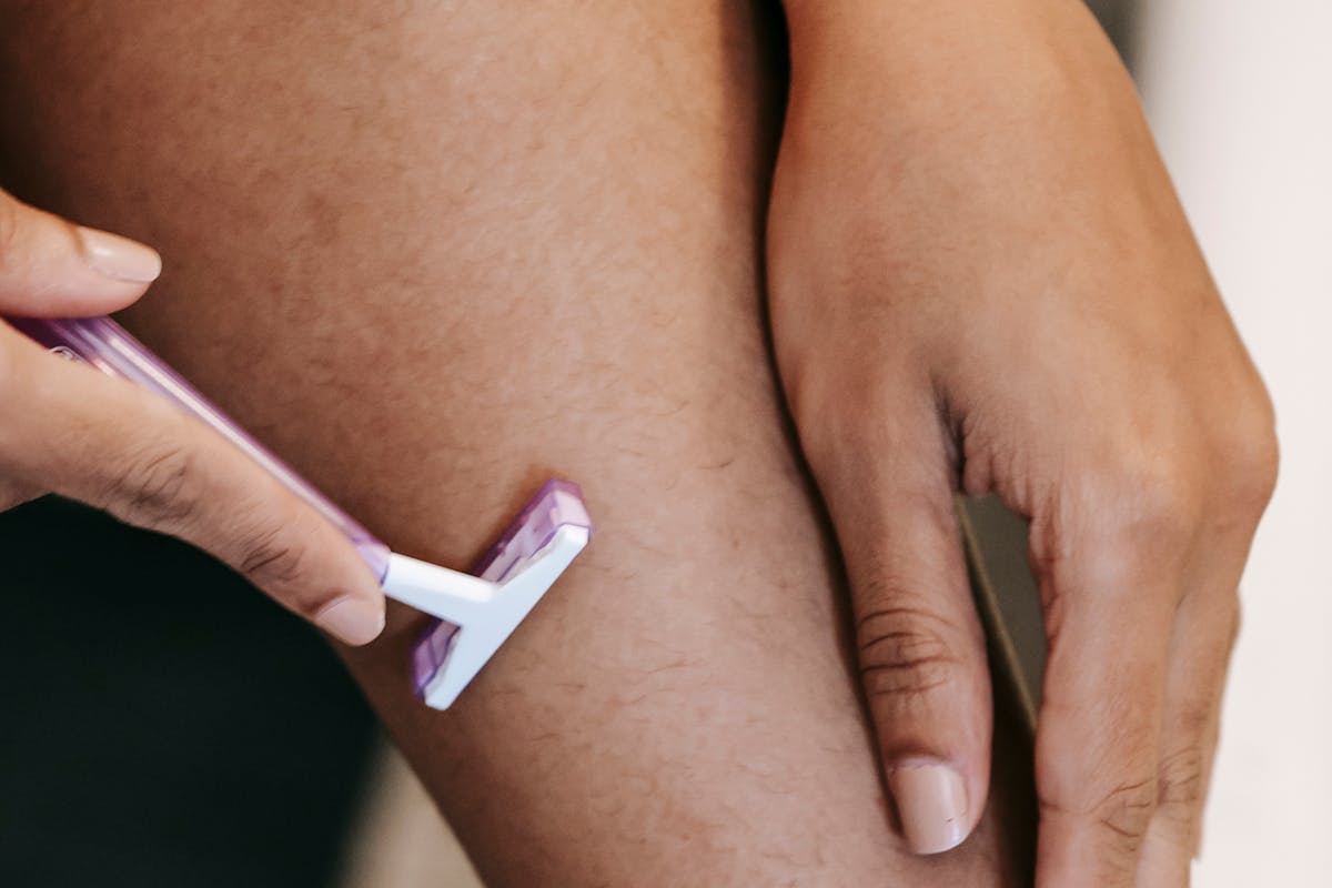 donna che passa rasoio su gamba depilata
